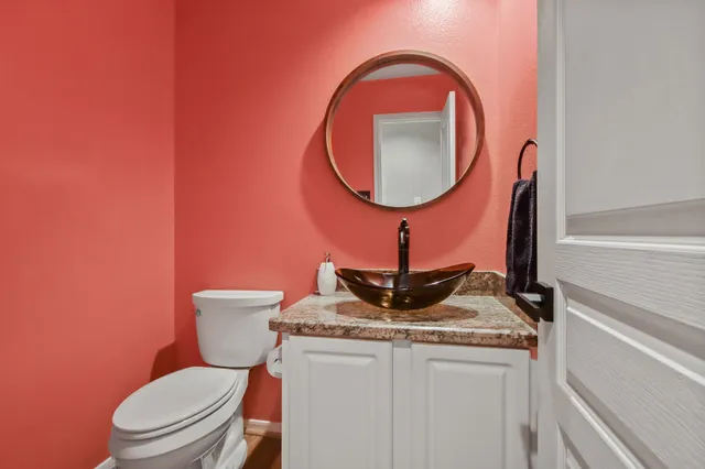 a bathroom with a toilet a sink and a mirror
