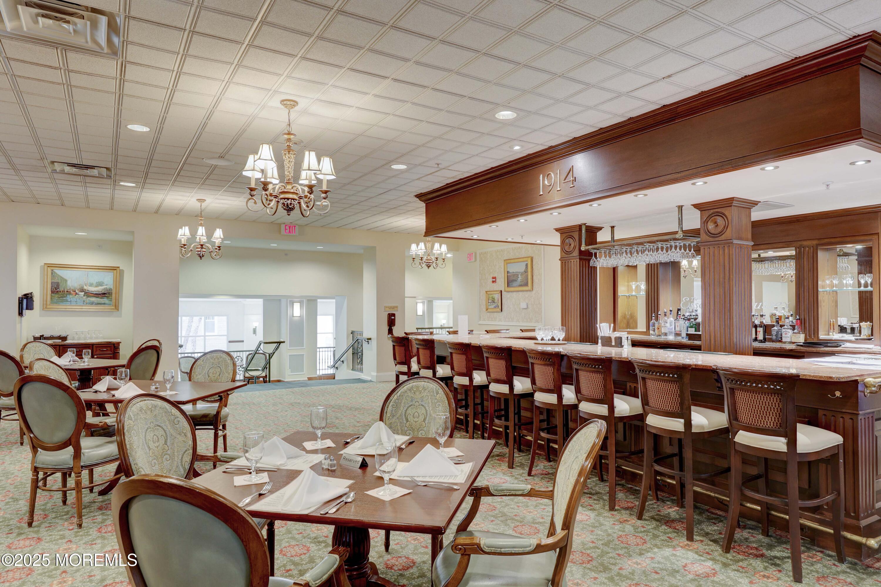 700 Ocean Avenue, Unit 531 Spring Lake, NJ 07762 - Photo 19 of 42 a large dining space with furniture a chandelier and window