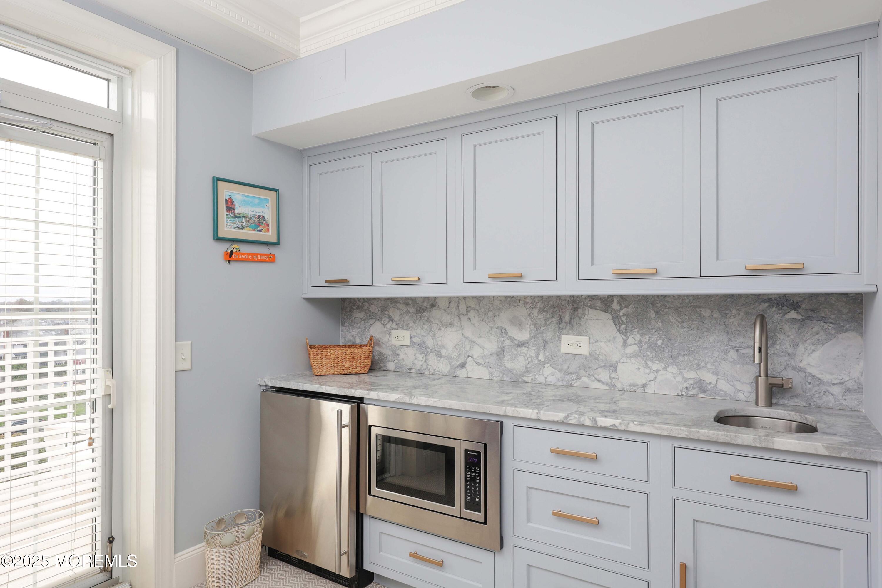 700 Ocean Avenue, Unit 531 Spring Lake, NJ 07762 - Photo 8 of 42 a kitchen with stainless steel appliances granite countertop white cabinets and window