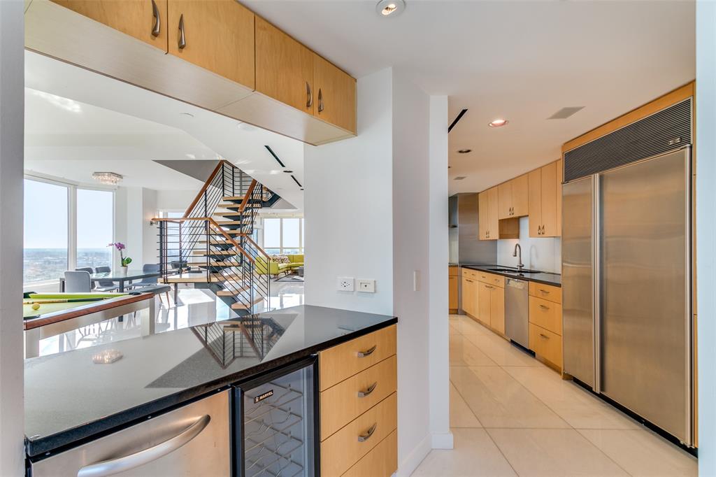 3030 McKinney Avenue, Unit 2301 Dallas, TX 75204 - Photo 11 of 34 a kitchen with stainless steel appliances granite countertop a sink and a refrigerator