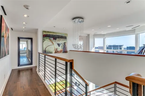 a view of a hallway with furniture and wooden floor