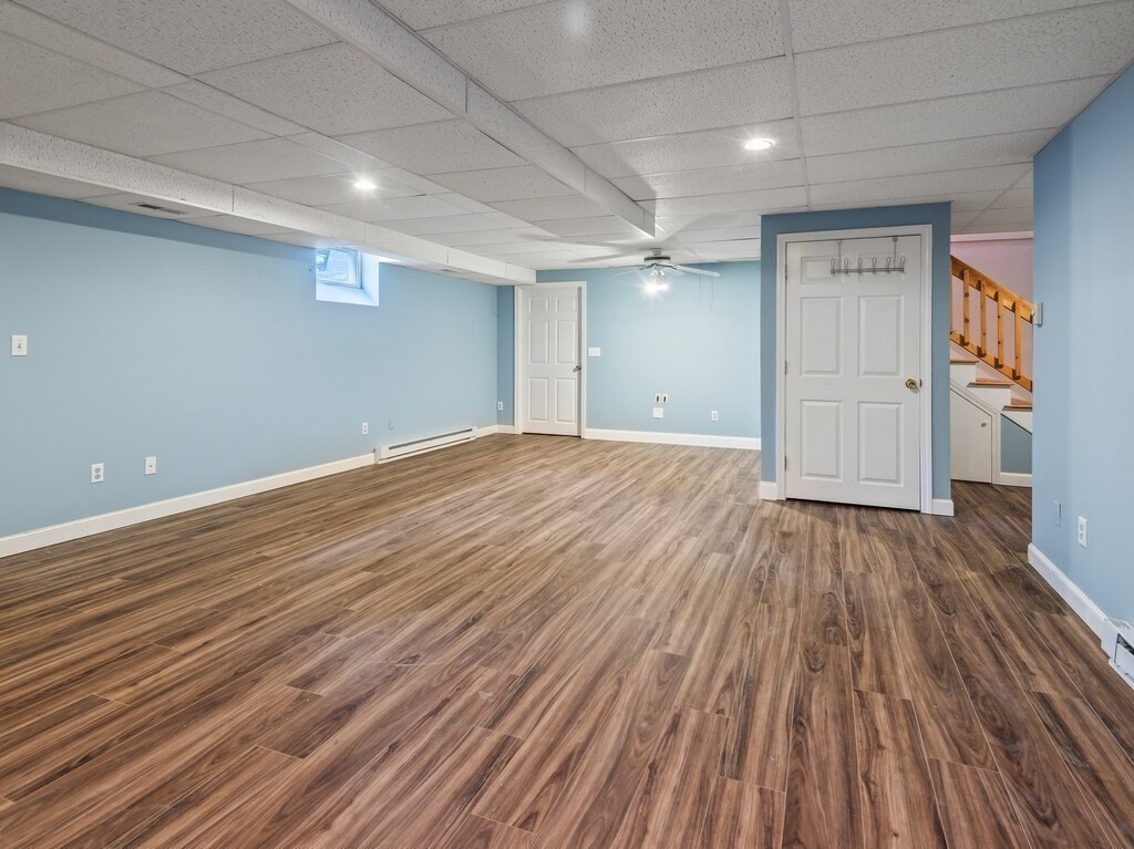 9 Santom Street Auburn, MA 01501 - Photo 31 of 42 an empty room with wooden floor and windows