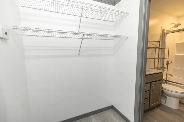 a bathroom with a granite countertop bathtub shower sink vanity and toilet