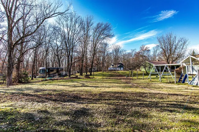 a view of a house with backyard and trees