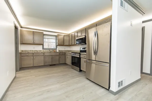 a kitchen with stainless steel appliances granite countertop a refrigerator sink and cabinets