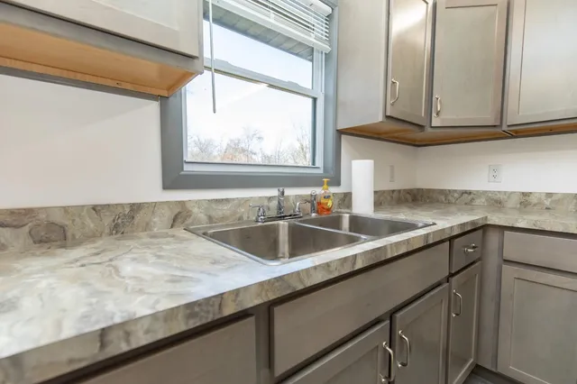 a kitchen with a sink cabinets and window