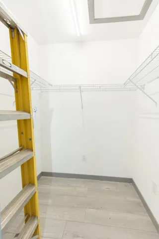 a view of walk in closet with empty racks