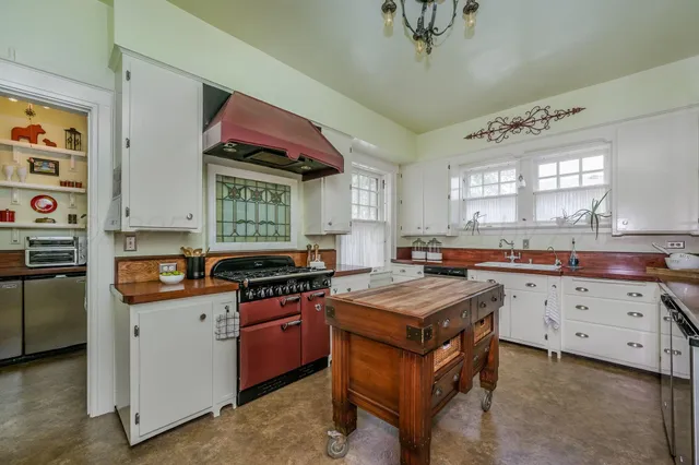 a kitchen with stainless steel appliances granite countertop a stove and a wooden floor