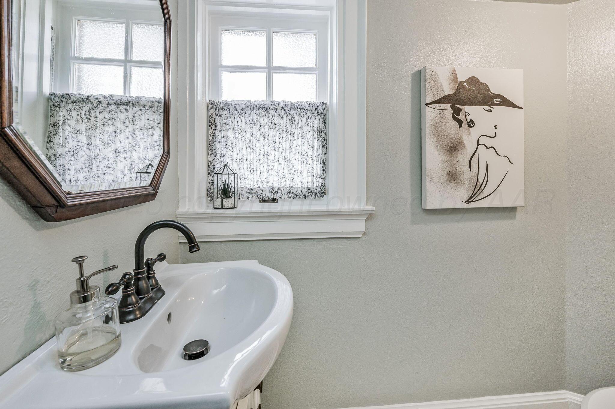 1620 South Tyler Street Amarillo, TX 79102 - Photo 22 of 66 a bathroom with a sink and a mirror