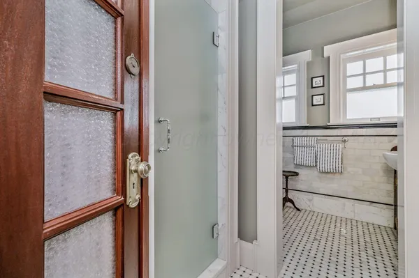 a view of a hallway with workspace and a window