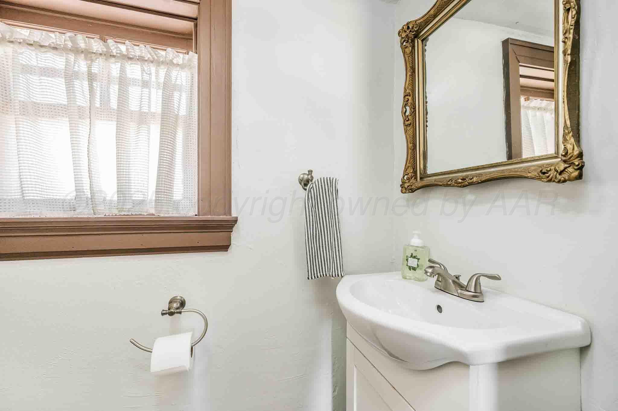 1620 South Tyler Street Amarillo, TX 79102 - Photo 49 of 66 a bathroom with a sink a mirror and a window