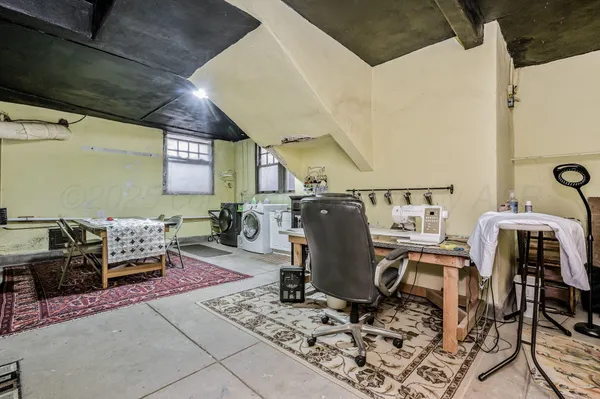a view of a backyard with large trees and wooden fence