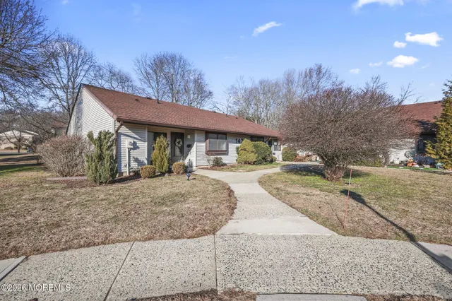 a front view of a house with a yard and trees