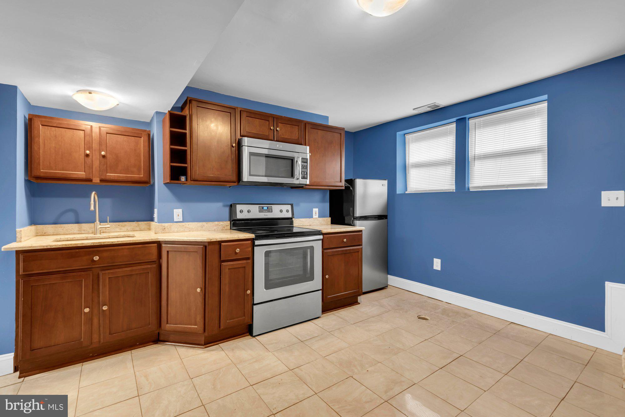 210 West Read Street Baltimore, MD 21201 - Photo 23 of 26 a kitchen with stainless steel appliances granite countertop a stove a sink and a microwave