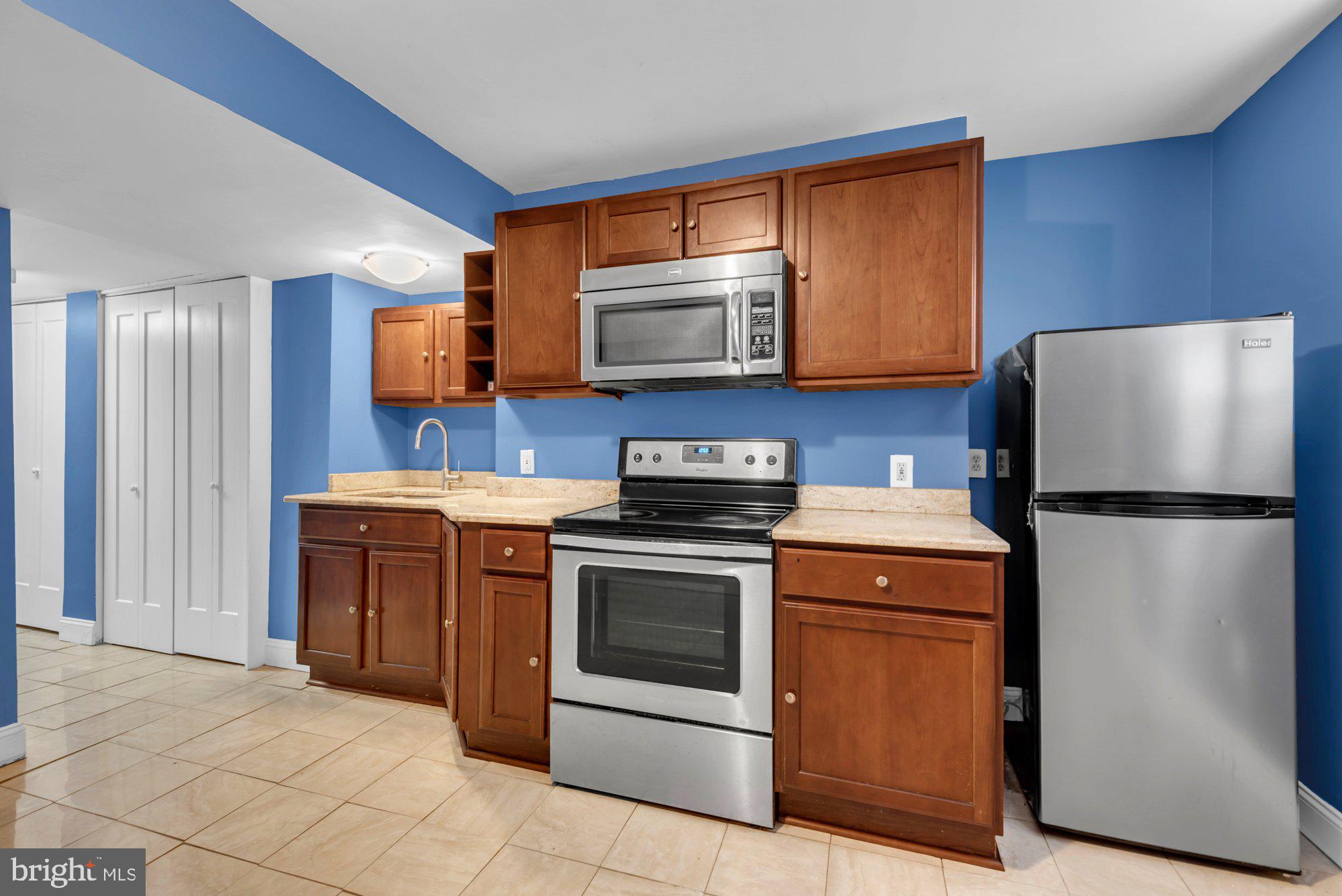 210 West Read Street Baltimore, MD 21201 - Photo 24 of 26 a kitchen with stainless steel appliances granite countertop a stove a refrigerator and a microwave