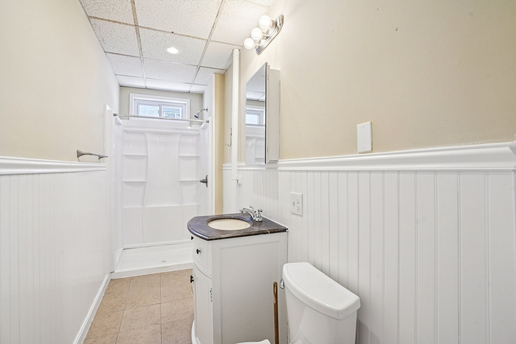 50 Whipple Street Worcester, MA 01607 - Photo 15 of 30 a bathroom with a granite countertop sink a toilet and a mirror