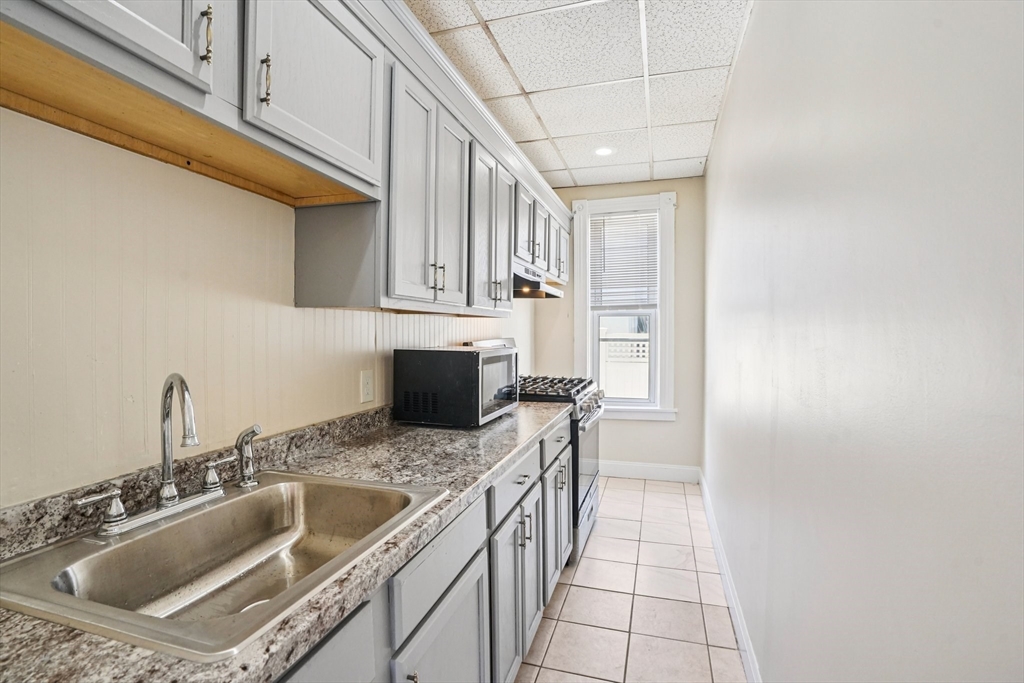 50 Whipple Street Worcester, MA 01607 - Photo 8 of 30 a kitchen with stainless steel appliances granite countertop a sink stove and cabinets