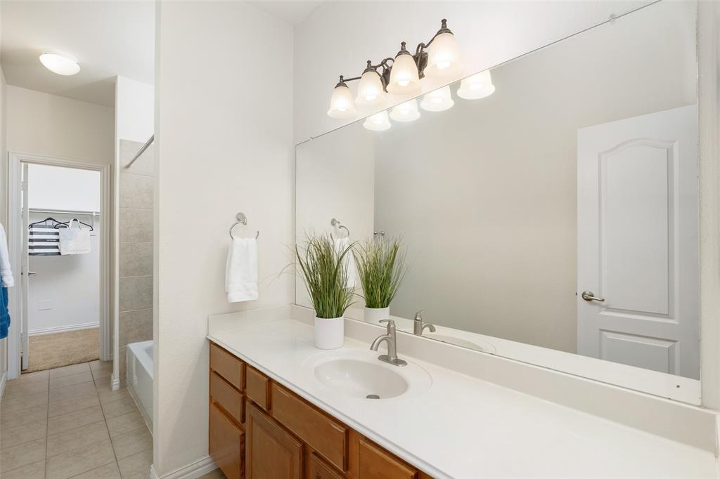 7113 Occidental Road Plano, TX 75025 - Photo 18 of 35 a bathroom with a sink a vanity and a mirror