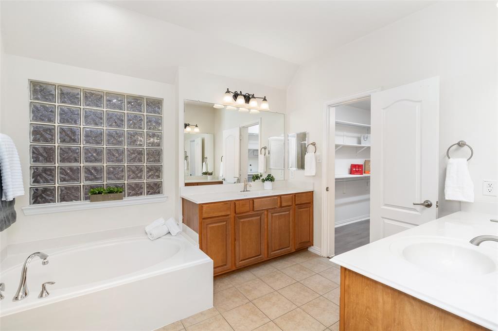 7113 Occidental Road Plano, TX 75025 - Photo 28 of 35 a bathroom with a tub sink and mirror