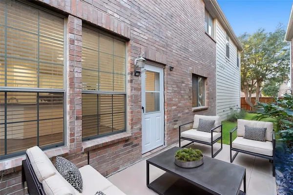 a view of a patio with couches and a table and chairs with wooden floor and fence