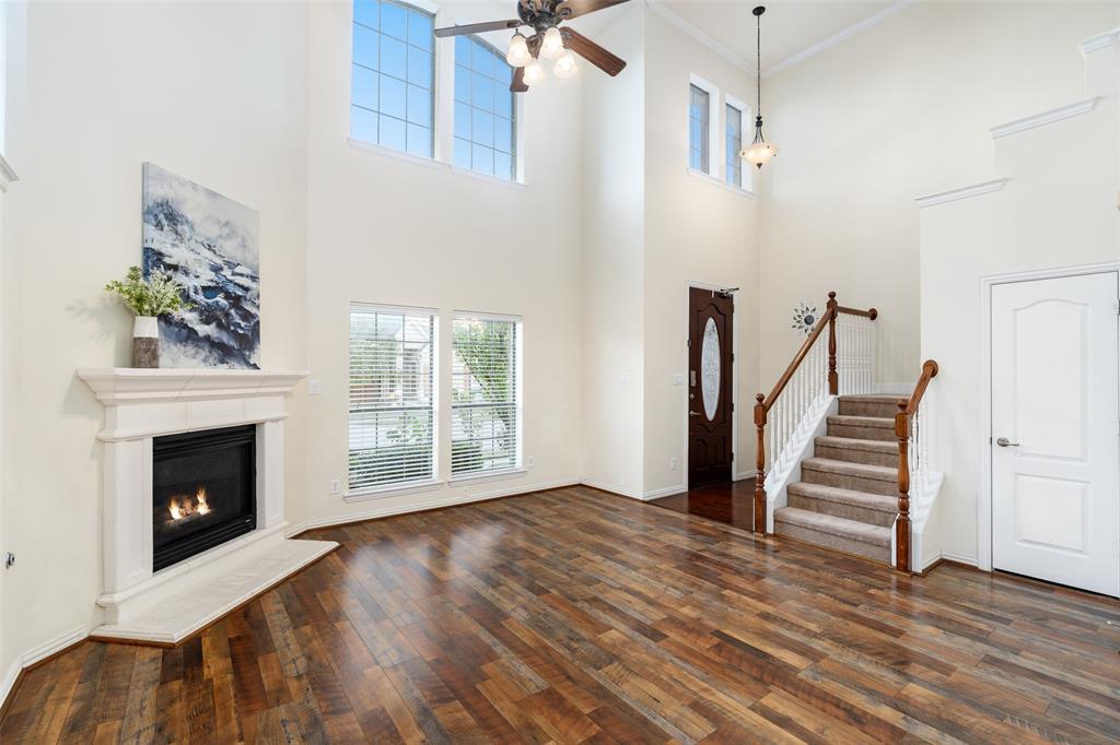 7113 Occidental Road Plano, TX 75025 - Photo 3 of 35 a view of an empty room with wooden floor fireplace and a window