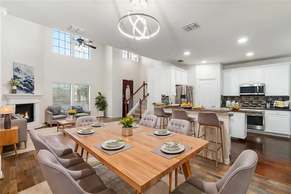 a view of a dining room with furniture a fireplace and wooden floor