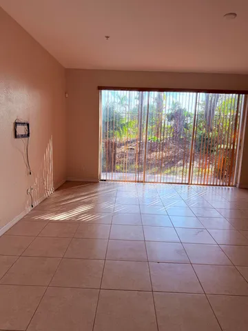 a view of an empty room with a floor to ceiling window and an empty room