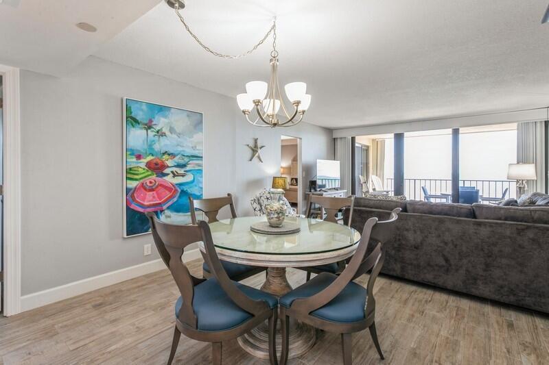 100 Ocean Trail Way, Unit 1010 Jupiter, FL 33477 - Photo 10 of 40 a view of a dining room with furniture a chandelier and wooden floor