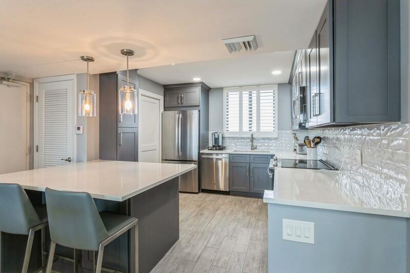 100 Ocean Trail Way, Unit 1010 Jupiter, FL 33477 - Photo 3 of 40 a kitchen with a sink cabinets and wooden floor