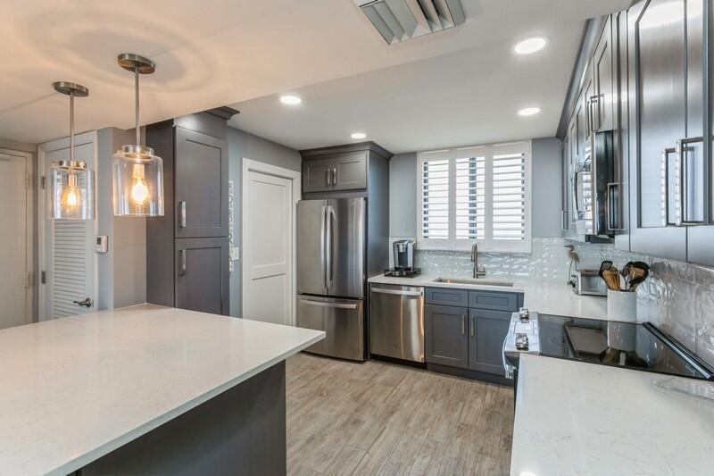 100 Ocean Trail Way, Unit 1010 Jupiter, FL 33477 - Photo 5 of 40 a kitchen with stainless steel appliances granite countertop a refrigerator a sink dishwasher a stove and white cabinets with wooden floor