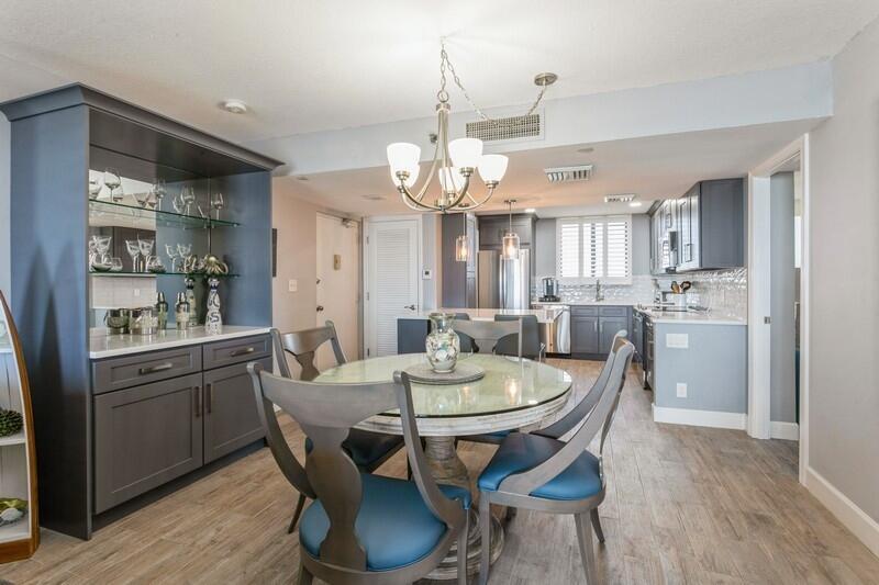 100 Ocean Trail Way, Unit 1010 Jupiter, FL 33477 - Photo 8 of 40 a view of a dining room and livingroom with furniture wooden floor a chandelier
