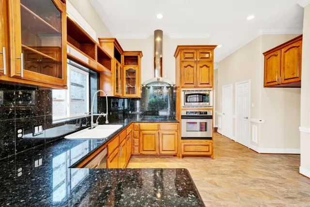 a view of a hallway with wooden floor and a chandelier