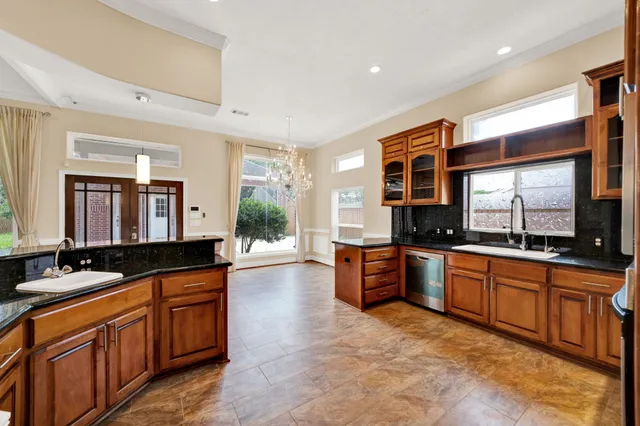 an empty room with wooden floor chandelier fan and windows