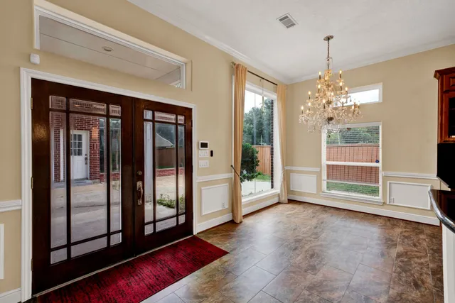 a view of an empty room with wooden floor and windows