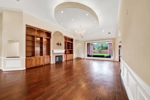 a kitchen with stainless steel appliances granite countertop a refrigerator a oven a sink and a dining table with wooden floor