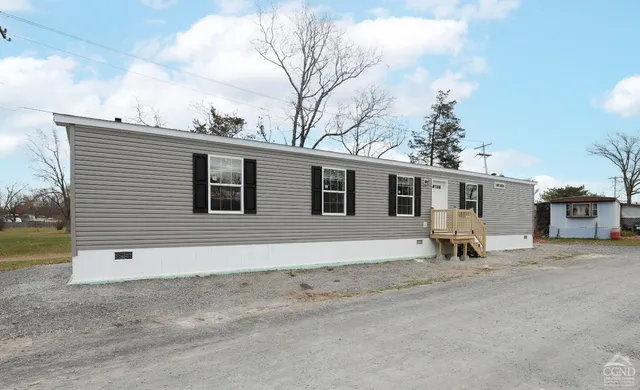 a backyard of a house with barbeque oven and outdoor seating