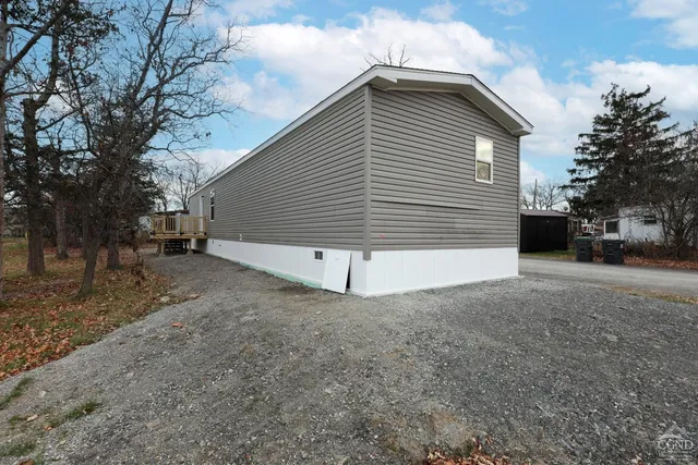 a view of a white house with a yard and stairs