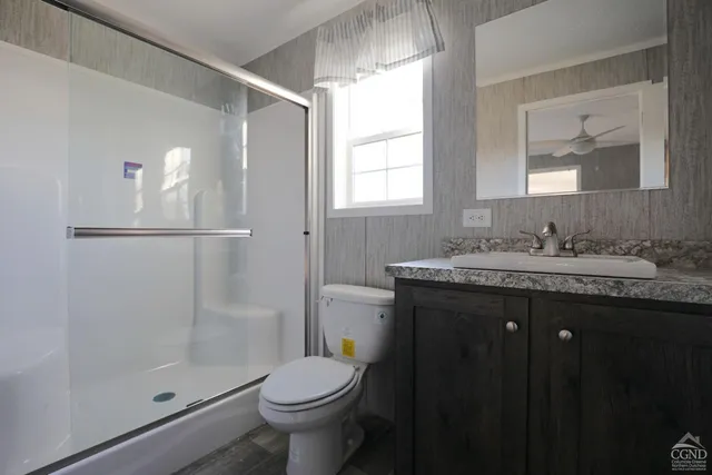 a bathroom with a granite countertop sink toilet and shower