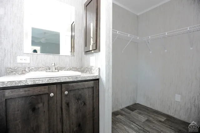 a bathroom with a granite countertop sink a mirror and a shower