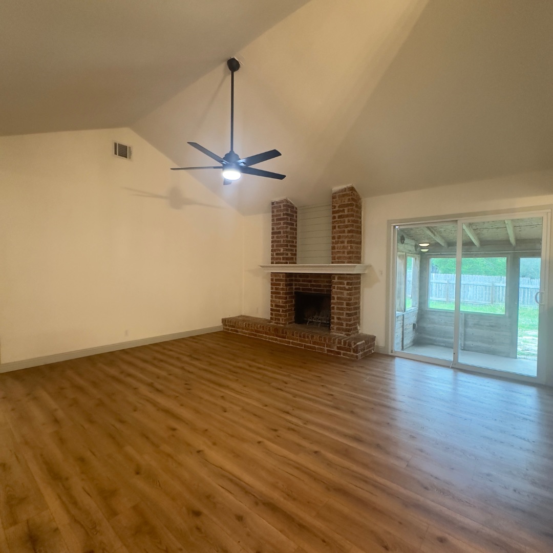504 Splitrock Round Rock, TX 78681 - Photo 7 of 11 Vaulted ceilings and a classic brick fireplace anchor this welcoming, open living space.