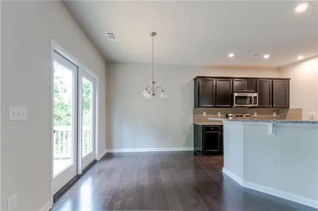 a view of kitchen with microwave and wooden floor