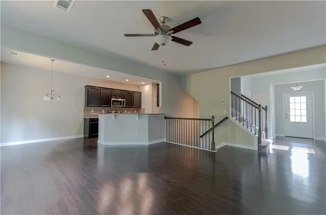 a view of empty room with wooden floor and a ceiling fan