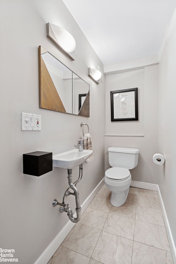 383 Grand Street, Unit M2002 Manhattan, NY 10002 - Photo 11 of 12 a bathroom with a toilet sink and mirror