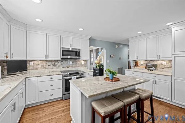 a kitchen with a stove a sink a dining table and chairs