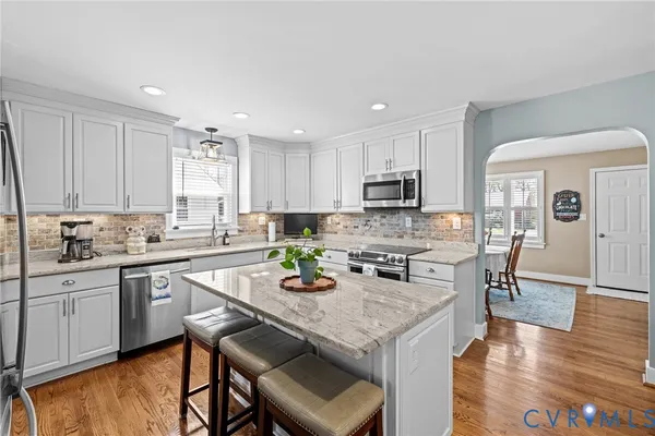 a kitchen with granite countertop white cabinets and appliances