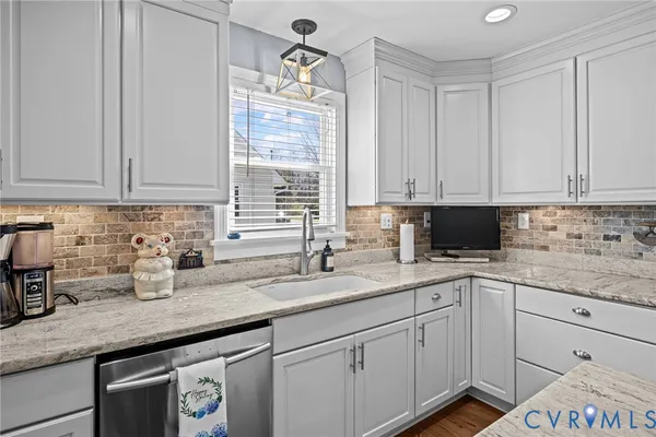 a kitchen with granite countertop a sink stainless steel appliances and cabinets