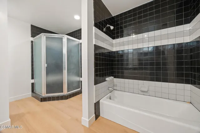 an empty room with wooden floor chandelier fan and windows