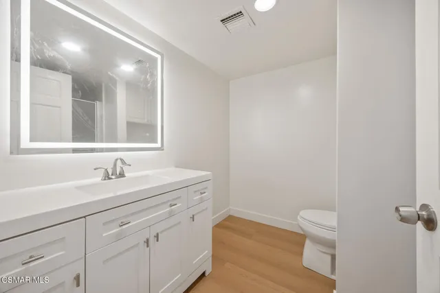 a bathroom with a sink a toilet and a mirror