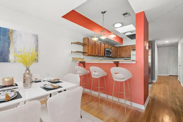 a kitchen with stainless steel appliances granite countertop a sink a stove and a wooden floors
