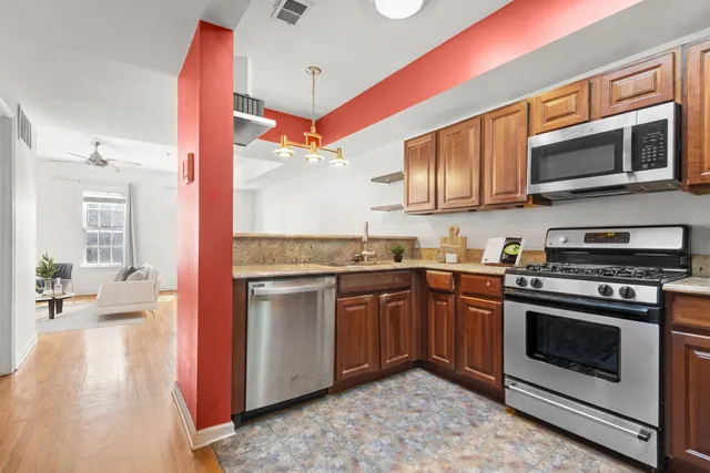 a kitchen with stainless steel appliances granite countertop a stove a sink and a microwave
